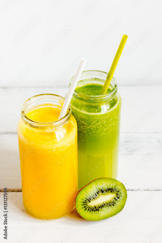 Fresh detox juices in glass bottles on white background