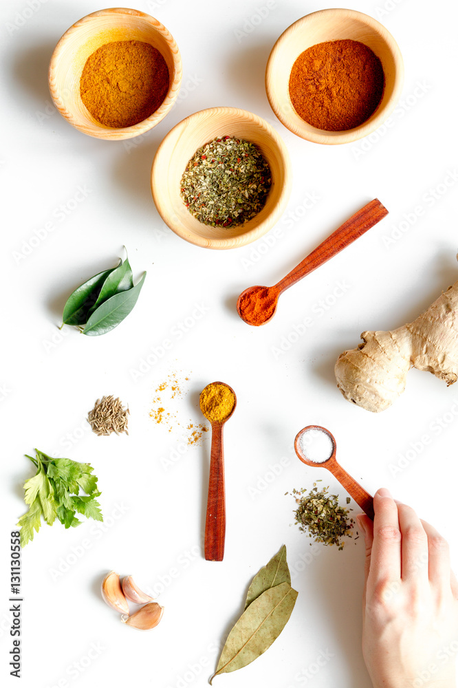 spices in wooden spoons on white background top view