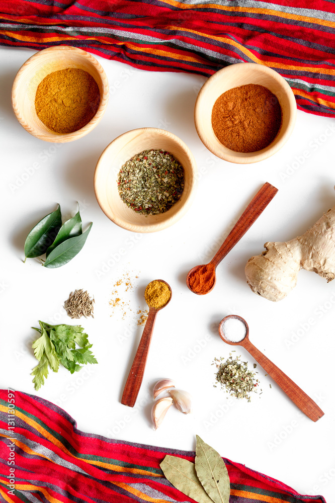 spices in wooden spoons on white background top view