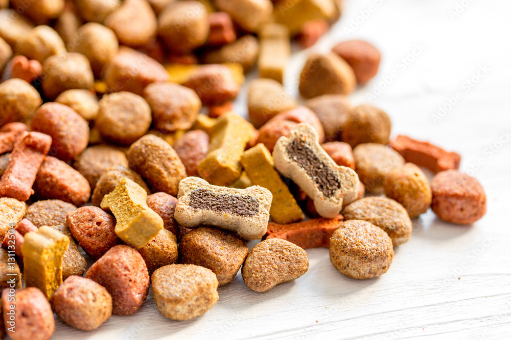 dry dog food in bulk on wooden background close up