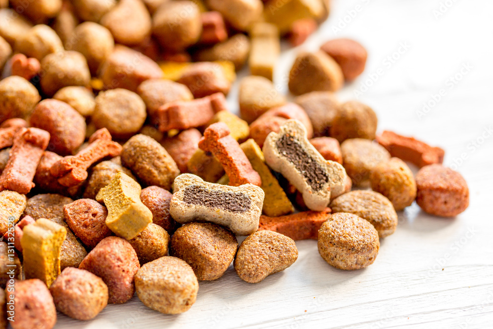 dry dog food in bulk on wooden background close up