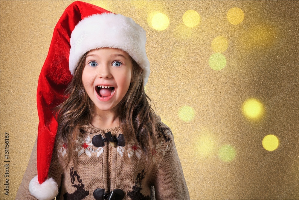 Happy child girl in a christmas hat.