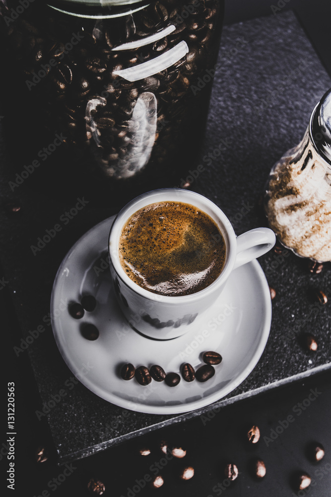 Coffee. Concept. Glass jar with beans and brown sugar cane on a dark background. Retro. Vintage. Top