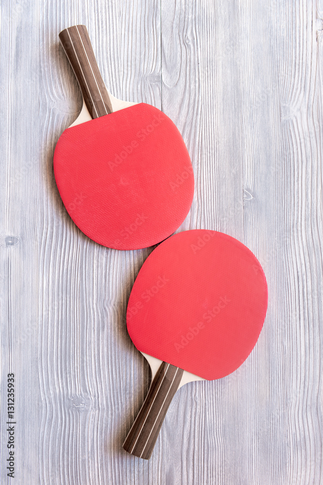 Red racket for ping pong ball wooden background top view