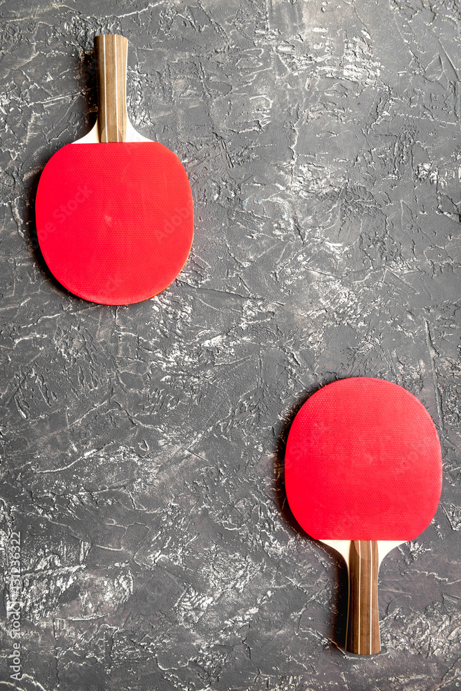 Red racket for ping pong ball gray background top view