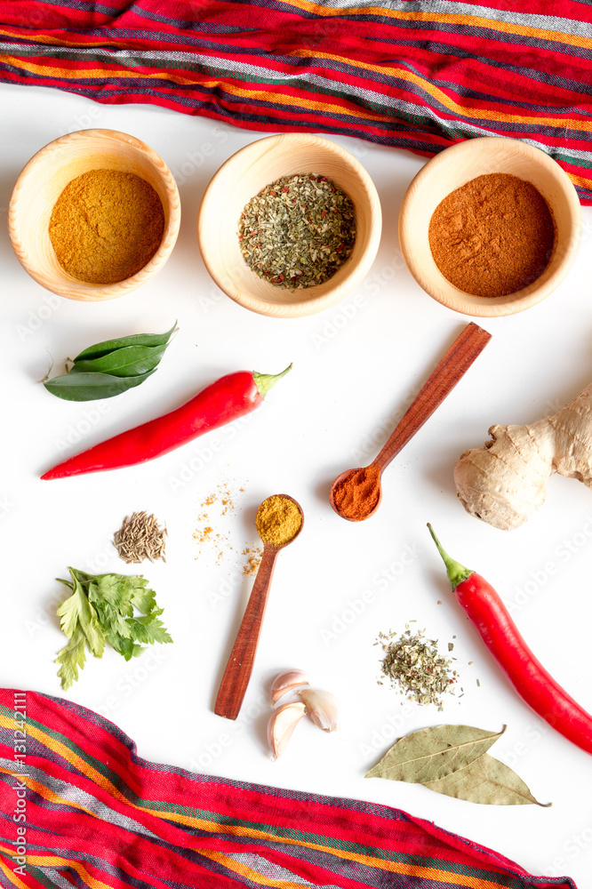 spices in wooden spoons on white background top view