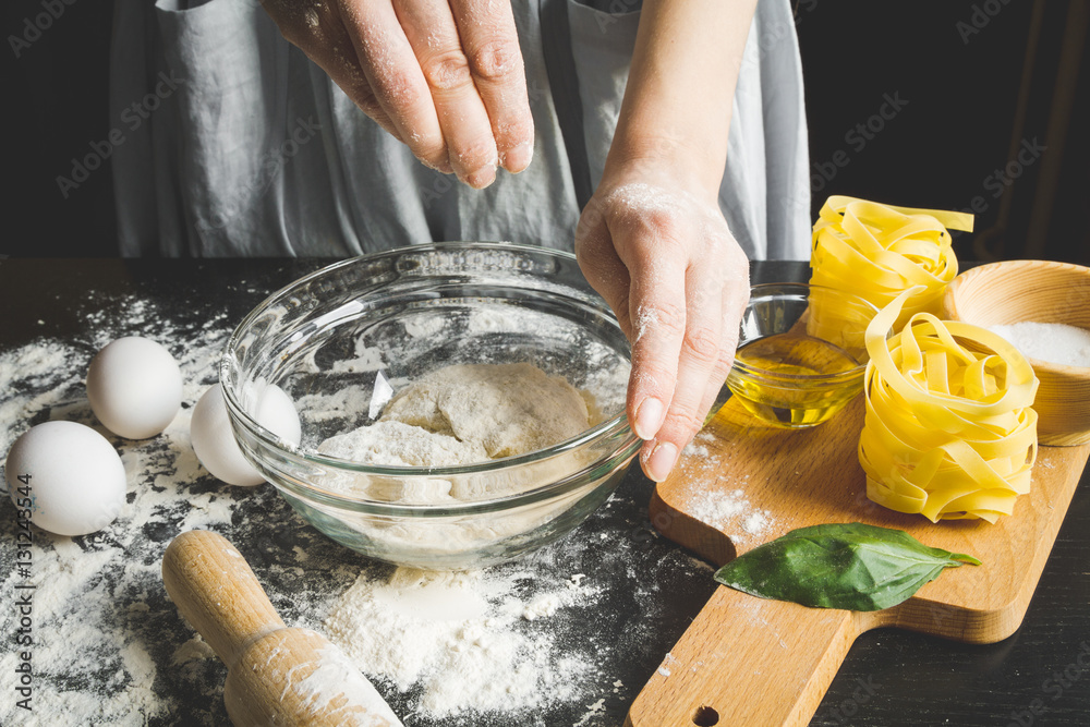 cooking pasta by chef in kitchen on dark background