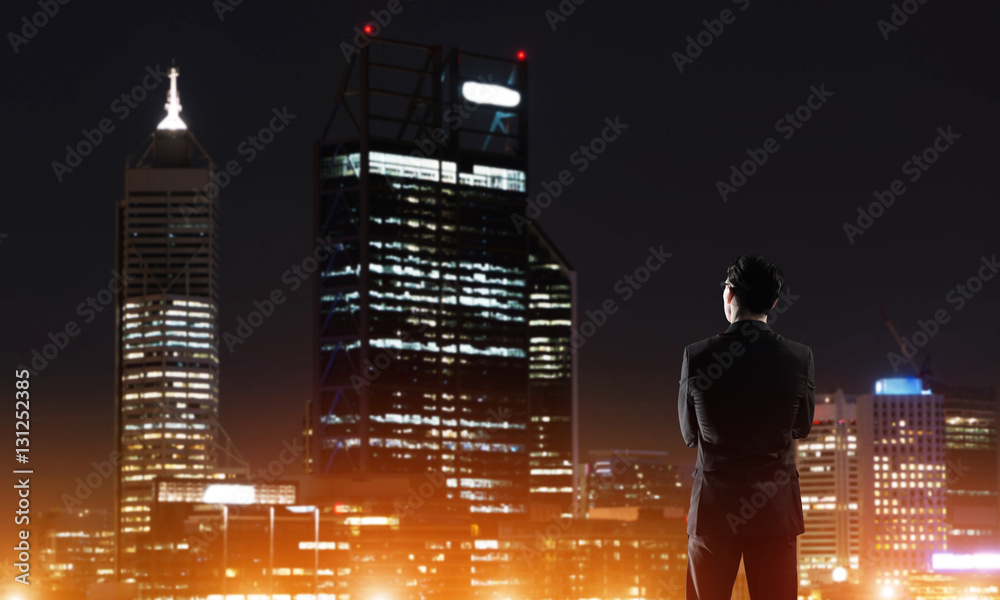 Businessman viewing night glowing city