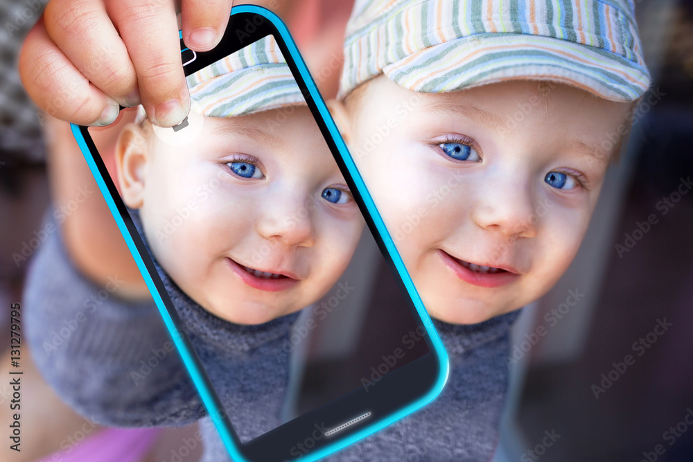 Little boy taking selfie with a cell phone camera