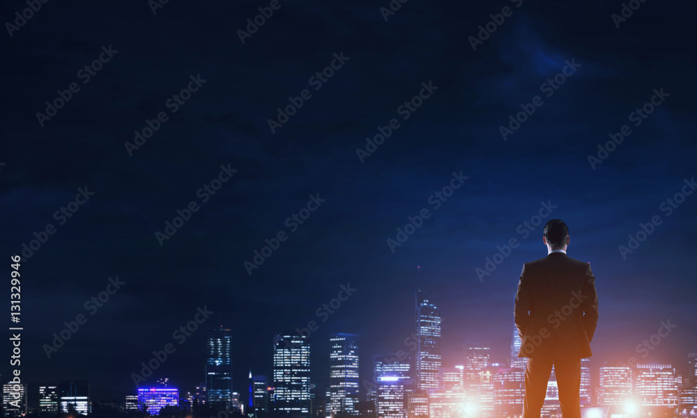 Businessman viewing night glowing city