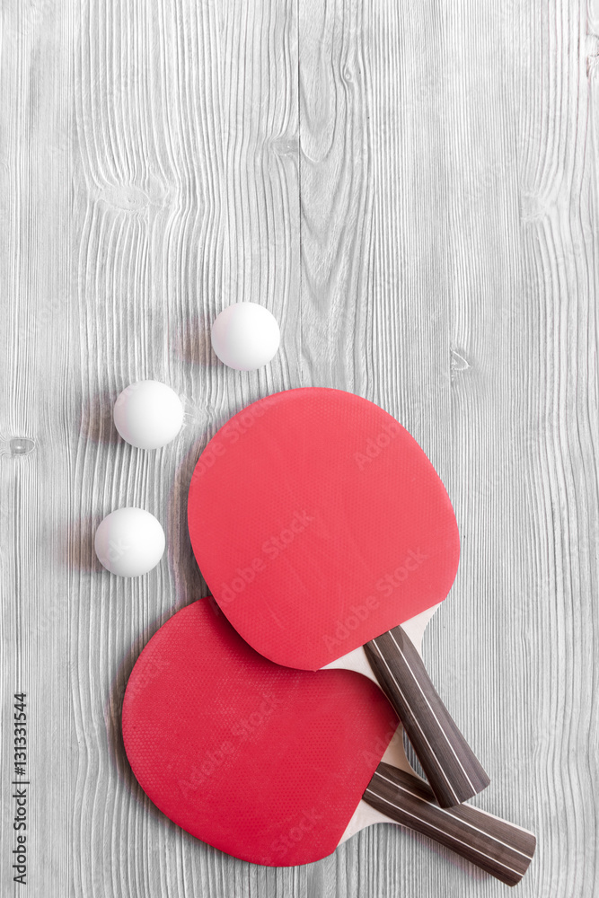 Red racket for ping pong ball wooden background top view