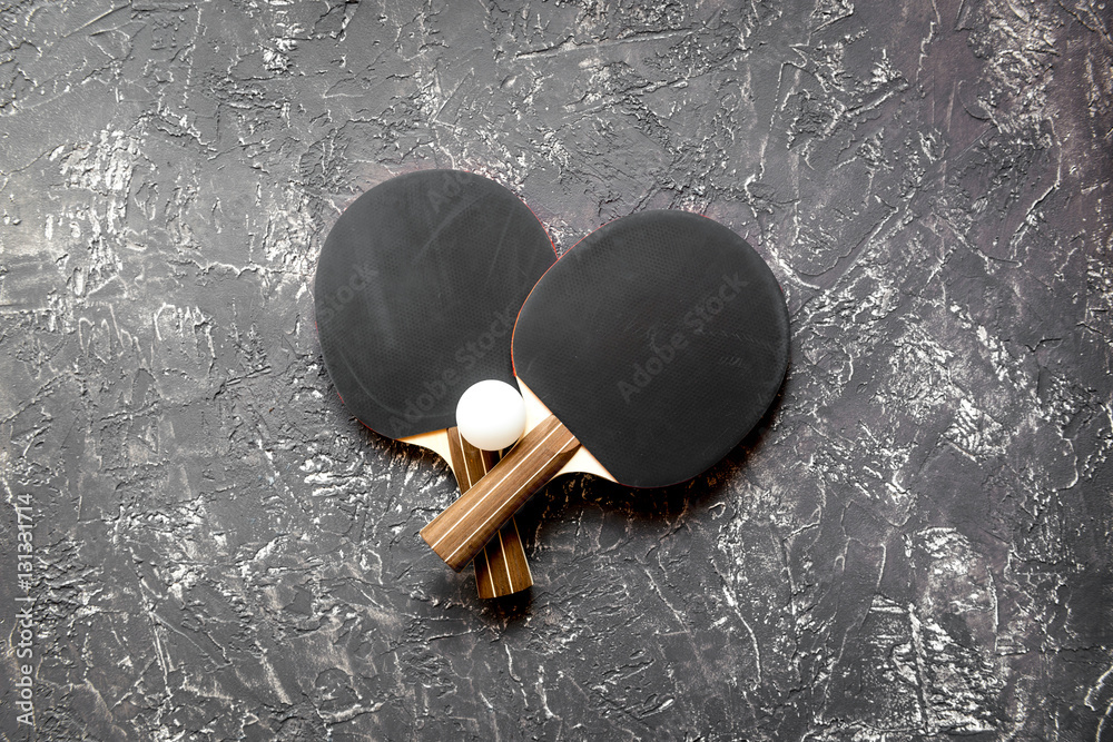 black racket for ping pong ball gray background top view