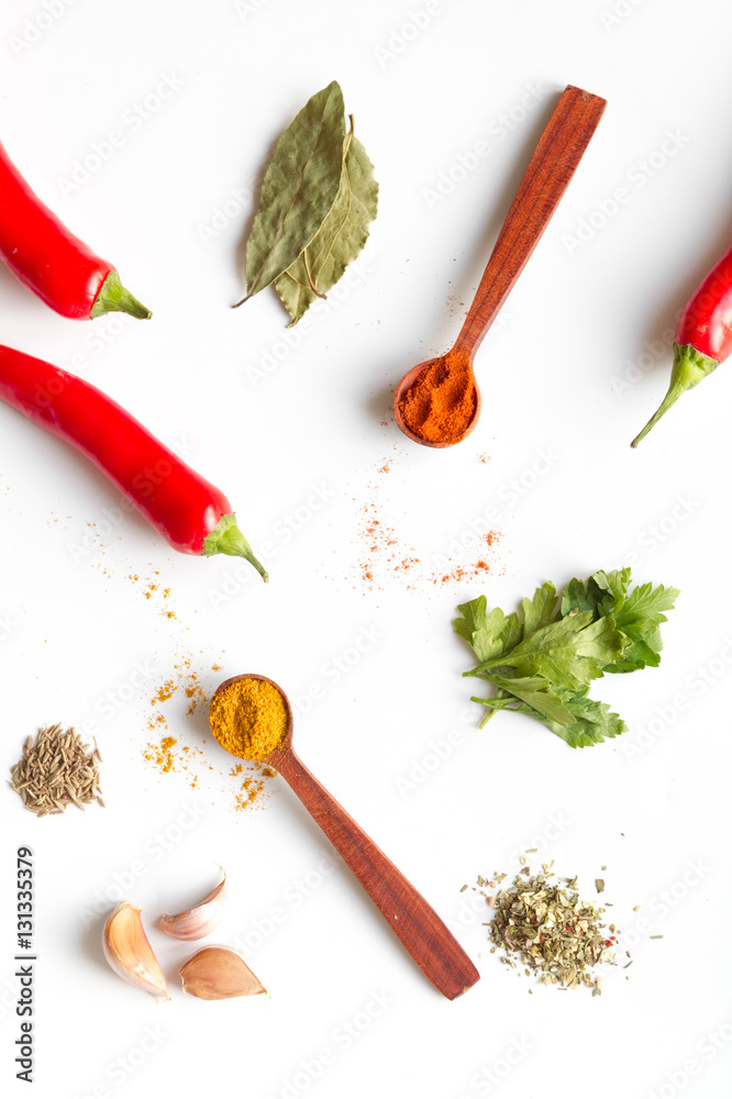 spices in wooden spoons on white background top view