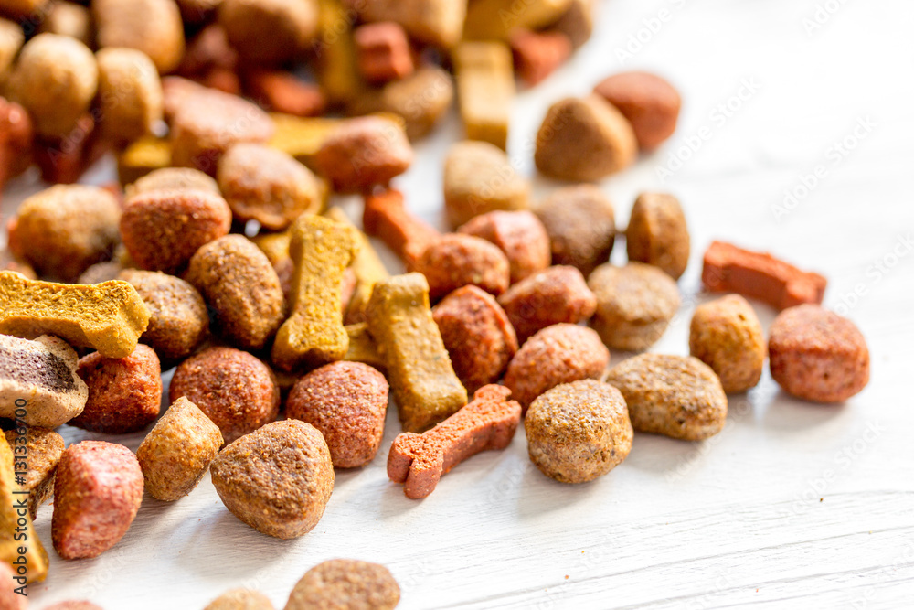 dry dog food in bulk on wooden background close up