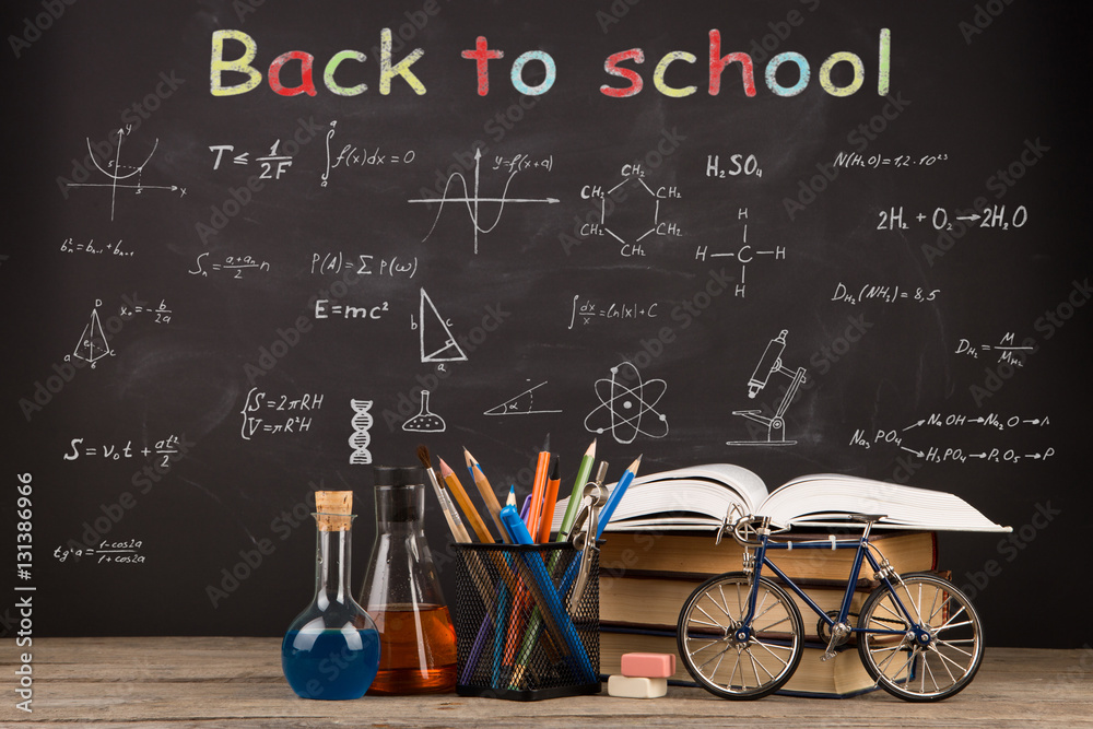 Back to school concept - books on the desk over the blackboard