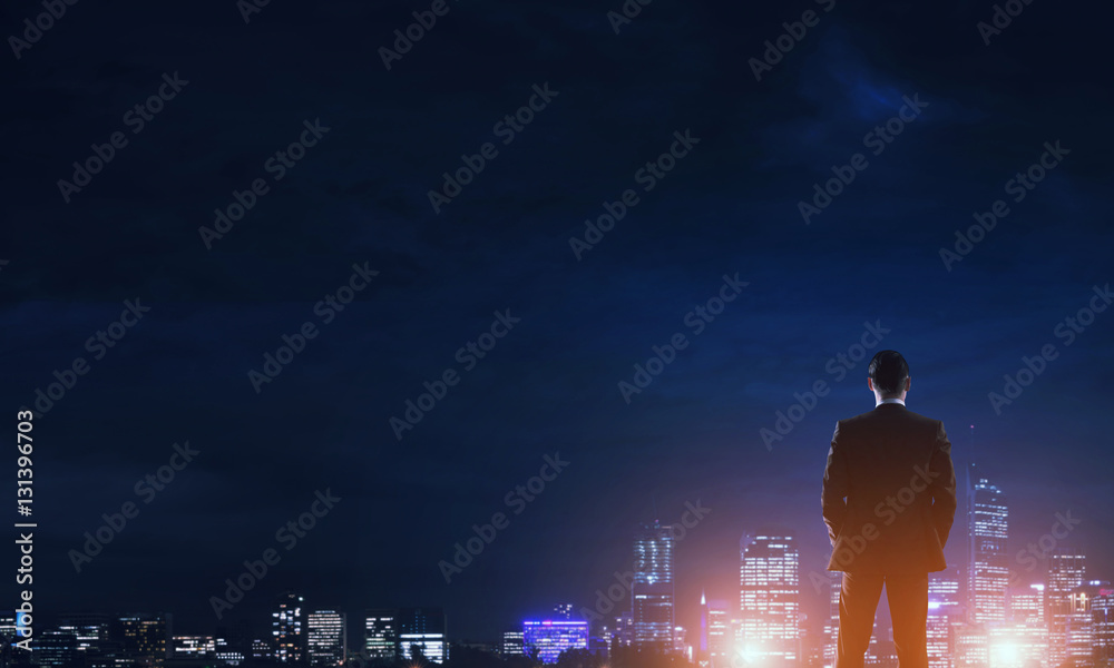 Businessman viewing night glowing city