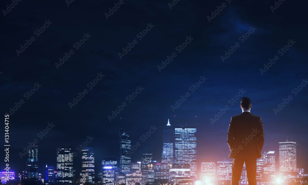 Businessman viewing night glowing city