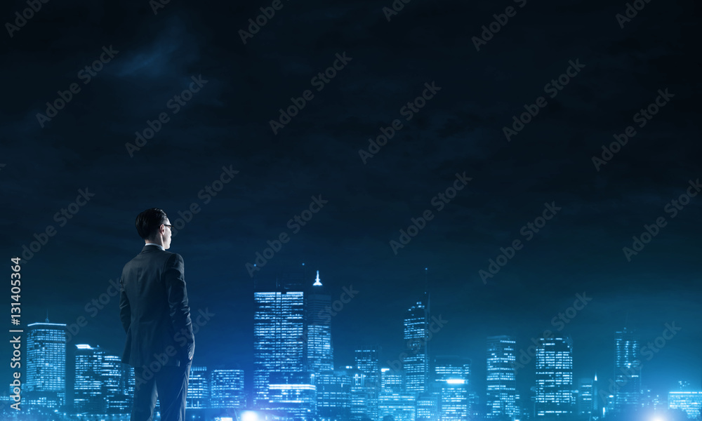 Businessman viewing night glowing city