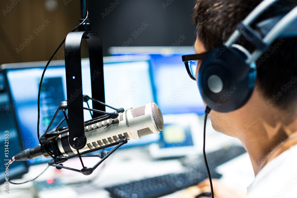 young man dj works in modern broadcast studio