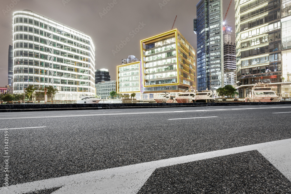 Asphalt road and modern cityscape at night in Shanghai