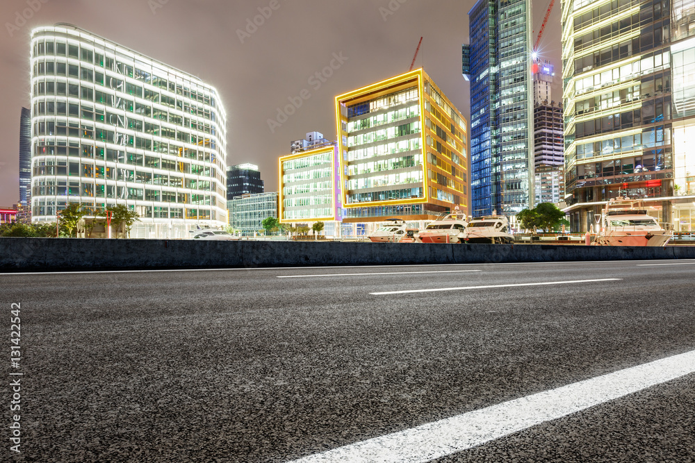 Asphalt road and modern cityscape at night in Shanghai