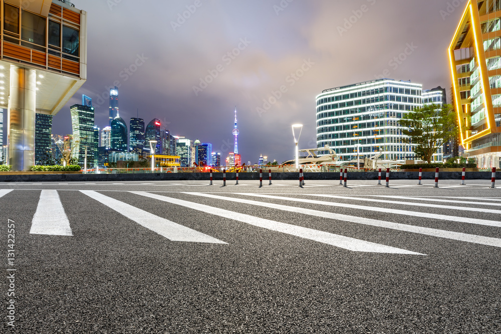 Asphalt road and modern cityscape at night in Shanghai