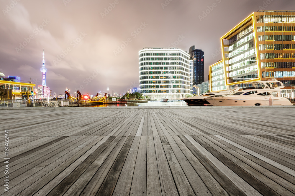 Empty floor with modern skyline and buildings at night in Shanghai