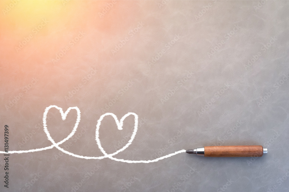 drawing of white heart shape with wooden pencil on blue backgrou