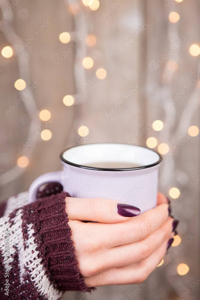 Woman in cozy sweater holding a cup