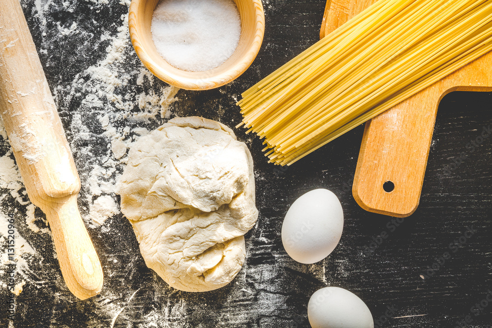 cooking process of pasta on dark background top view