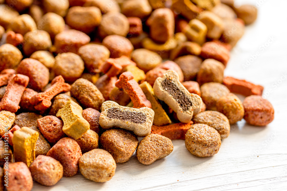 dry dog food in bulk on wooden background close up