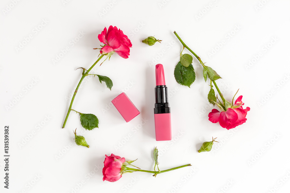 berry color decorative cosmetics with roses white background top view