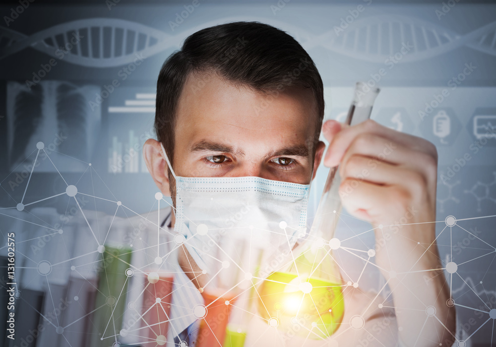 Young scientist mixing reagents in glass flask in clinical laboratory