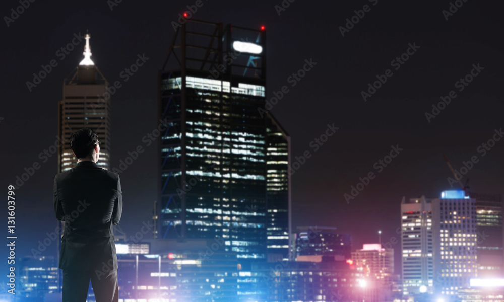 Businessman viewing night glowing city