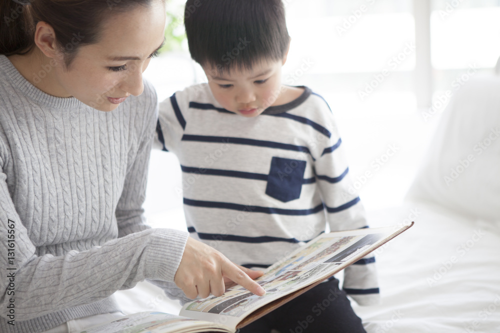 Mother and son are reading a picture book in my bedroom