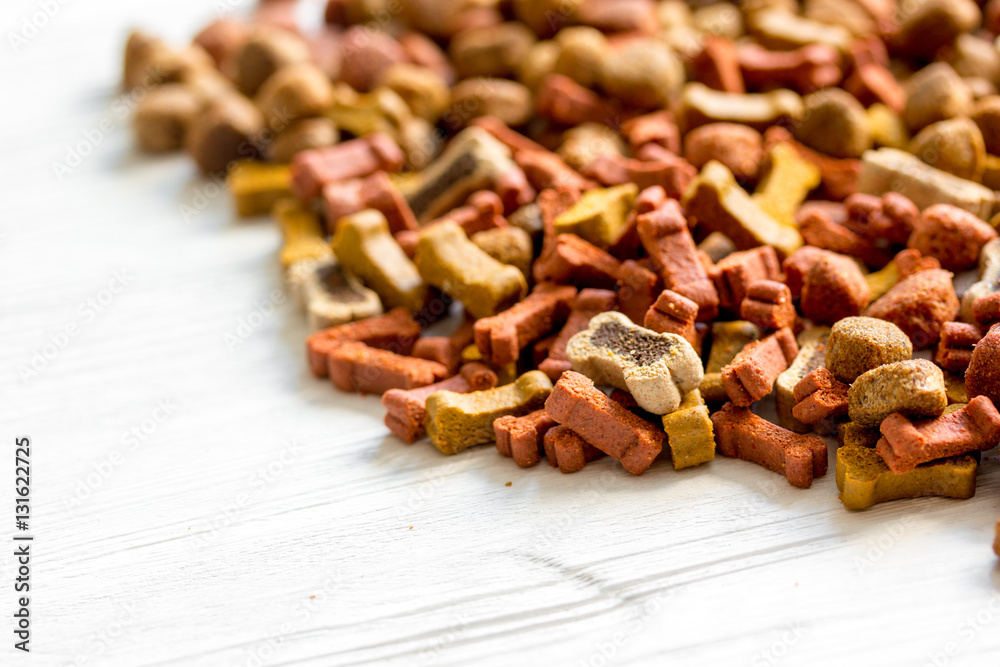 dry dog food in bulk on wooden background close up