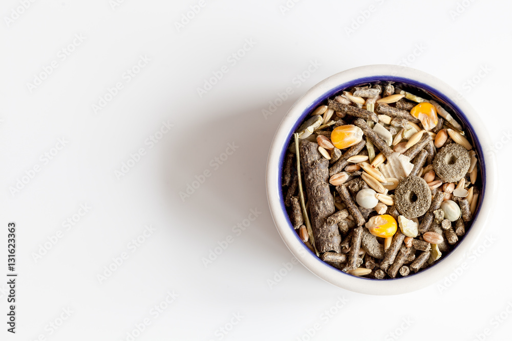 dry food for rodents in bowl white background top view