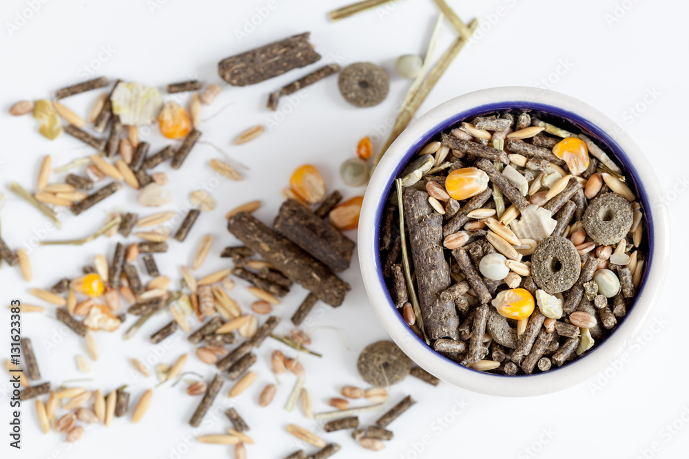 dry food for rodents in bowl white background top view