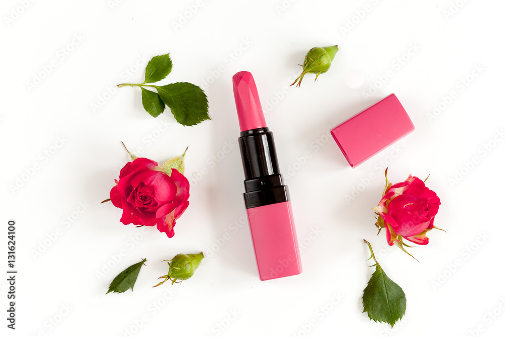 berry color decorative cosmetics with roses white background top view