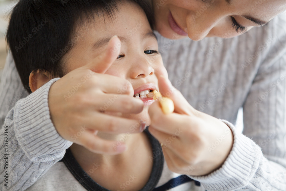 Mother is brushing her sons teeth