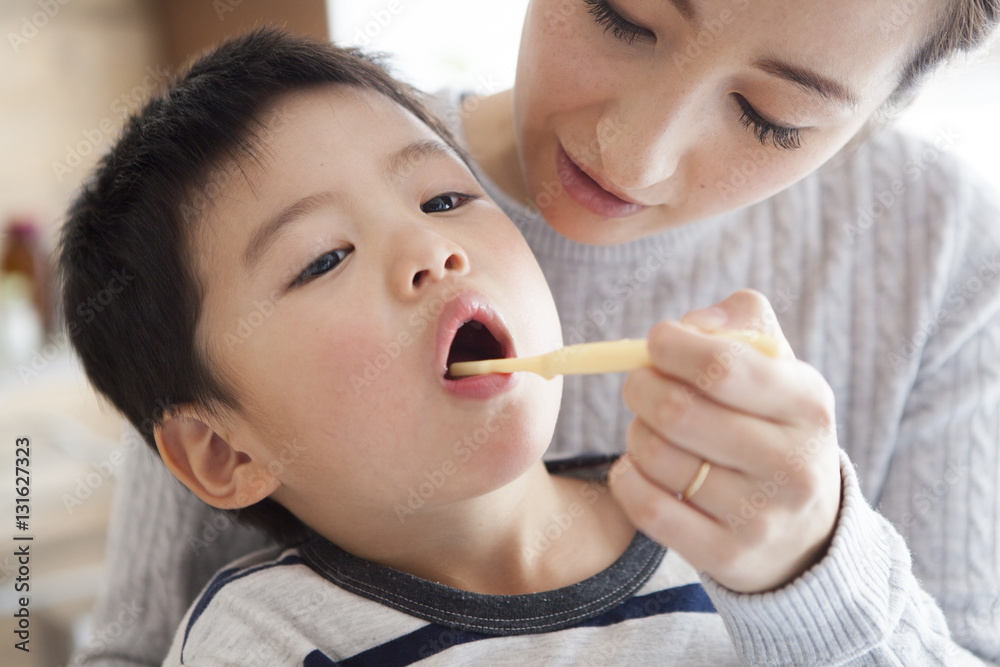 Mother is brushing her sons teeth