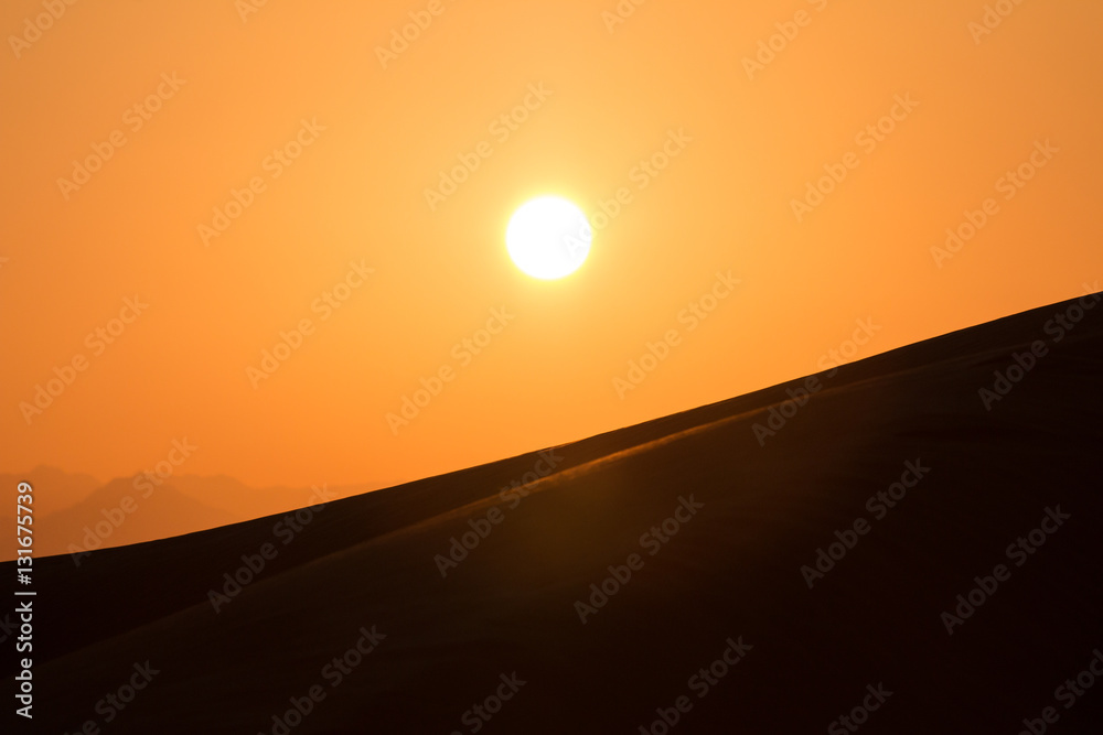 Hot sunrise in the desert dunes of Dubai, United Arab Emirates.