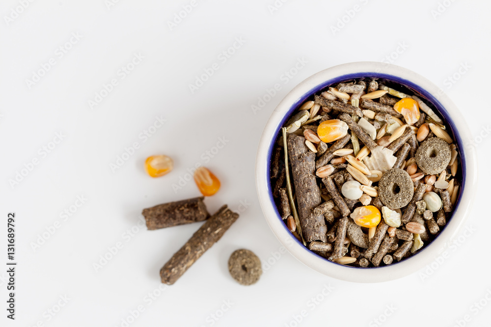 dry food for rodents in bowl white background top view