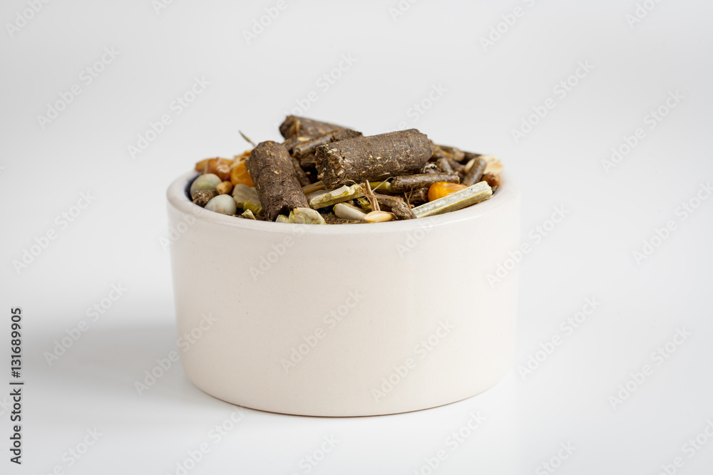 dry food for rodents in bowl white background