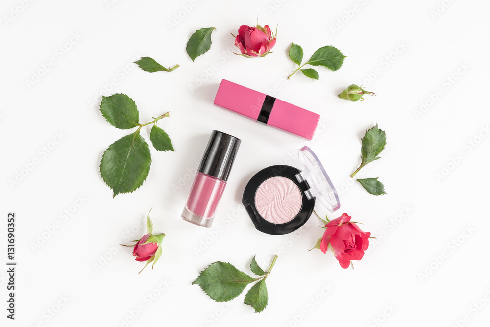 berry color decorative cosmetics with roses white background top view