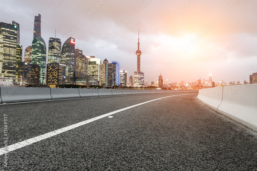 Asphalt road and modern cityscape at sunset in Shanghai