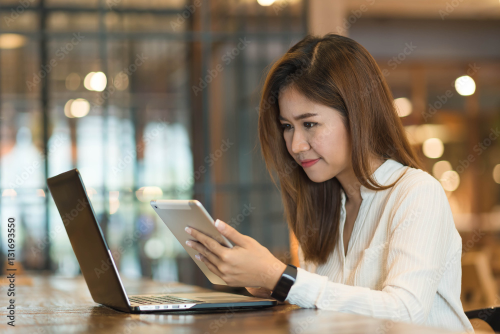 woman, freelance working with laptop and tablet in coffee shop,