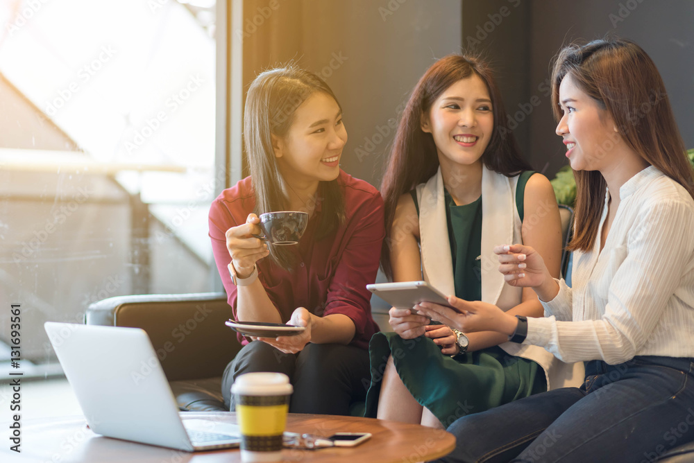 Group of friends happily hang out in a coffee shop chatting to e