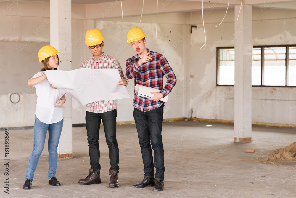 three construction engineers working together in side building