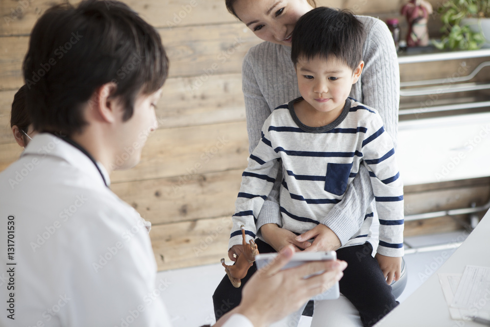 医生正在向家长和孩子展示电子平板电脑